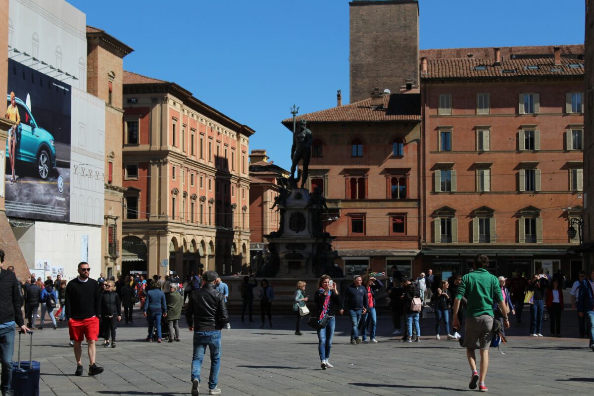 Persone che camminano sulla strada vicino all'edificio in cemento marrone durante il giorno